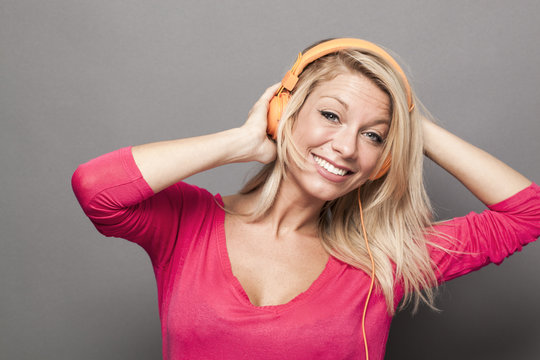 excited young beautiful woman dancing with headphone on