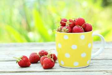 Strawberries berry in cup on grey wooden background