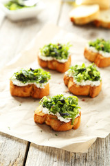Tasty fresh bruschetta on parchment on grey wooden background