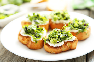 Tasty fresh bruschetta on plate on grey wooden background