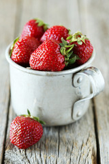 Strawberries berry in cup on grey wooden background