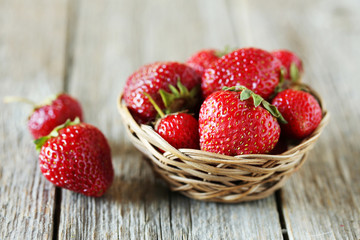 Strawberries berry in basket on grey wooden background