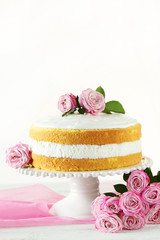 Sweet cake on cake stand on white wooden background