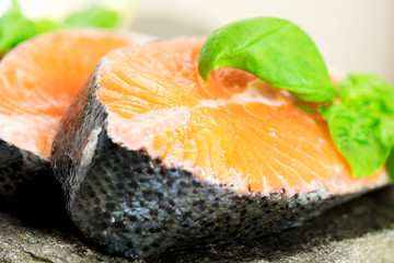 Salmon on stone with basil and lemon close up