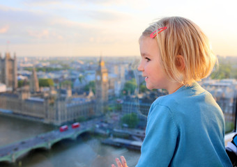 Family with young children enjoying trip to UK. Kids looking through the window of London Eye wheel. Beautiful view on London's southern part: cityscape, Westminster Abbey, Big Ben and Thames river