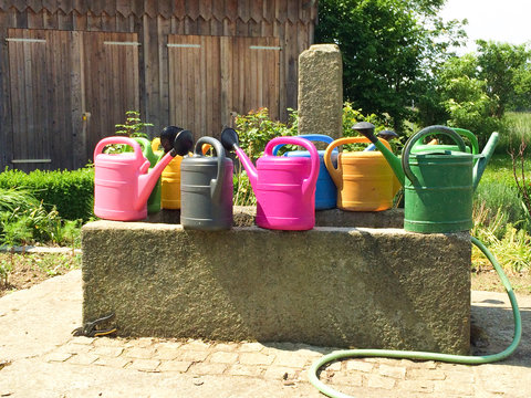 bunte Gie&szlig;kannen im Garten