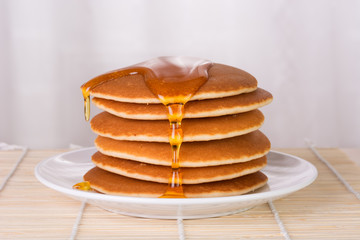 Stack of pancakes with syrup or honey