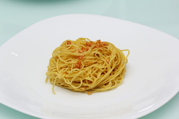 cooked egg noodles with fried galic on white plate