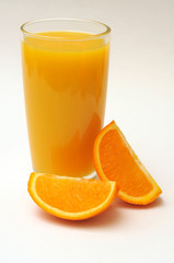 Orange juice in a glass and oranges