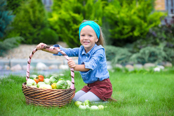 Little girl with baskets full of tomatoes 