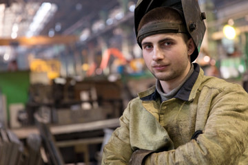 Portrait factory welder worker on manufacture workshop background