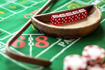 5 Dice in a bowl and a stick on a craps table - obrazy, fototapety, plakaty