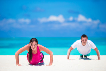 Young fitness couple doing push-ups during outdoor cross