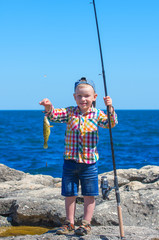 Little boy with a smile holding a fishing rod with his first cat