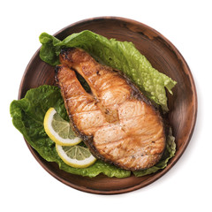 Baked steak trout with lemon and salad on white background