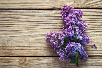 Branch of lilac on a wooden table with space for text