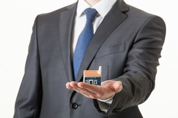 Unrecognizable businessman holding a toy house