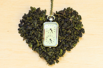 Green tea leaves heart shaped and watch