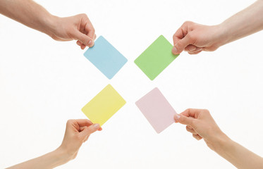 Human hands holding colorful paper cards