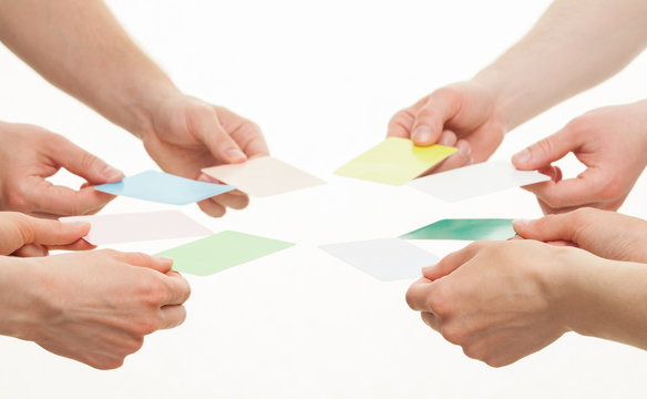 Human hands reaching out colorful paper cards