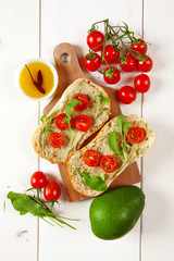 sandwich with cherry tomatoes and cream of avocado and arugula