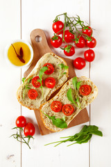 sandwich with cherry tomatoes and cream of avocado and arugula