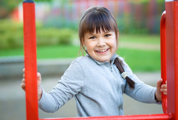 Fototapeta na wymiar Cute little girl is playing in playground