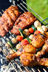 Assorted meat and vegetables on barbecue grill cooked for summer family dinner