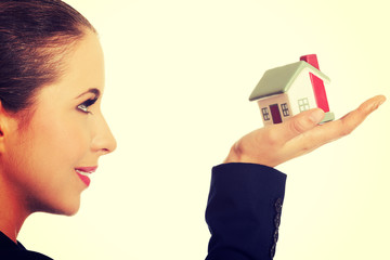 Woman with small model house on hand