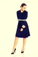 Businesswoman wrapped with metal chain.