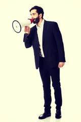 Fototapeta premium Businessman shouting using a megaphone.