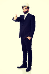 Engineer in protective helmet with thumbs up.