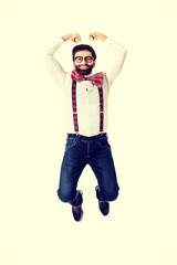 Old fashioned man wearing suspenders jumping.