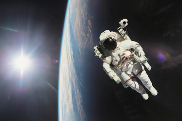 Astronaut in outer space with planet earth as backdrop. Elements