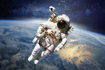 Astronaut in outer space with planet earth as backdrop. Elements - obrazy, fototapety, plakaty