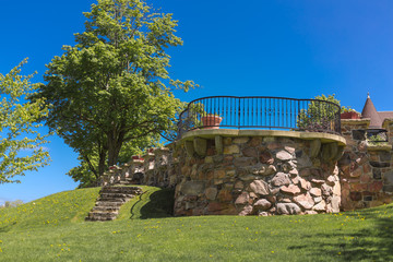 Obraz premium fragment of view of exterior back yard decorative stone view point balcony in garden against blue sky background