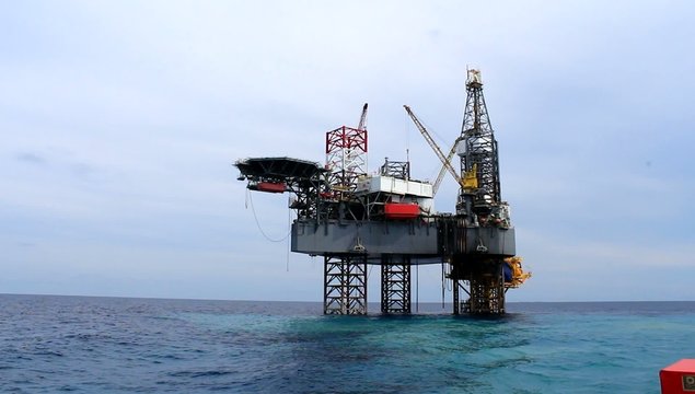 Jack up drilling rig and water spout in the middle of the ocean 
