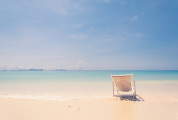 beach chair on beach with blue sky - soft focus with film filter