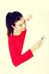 Naklejka premium Smiling woman holding blank banner and pen