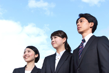 Asian businessman and businesswoman looking up at the sky