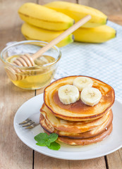 Stack of pancakes with banana and honey