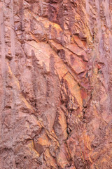 Texture of mountain showing red soil and rock