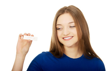 Happy teenager holding pregnancy test.