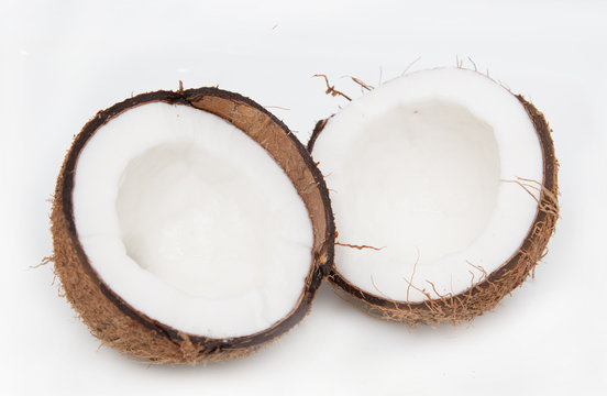 halves of coconut on white background