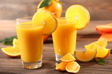 Orange juice on table on wooden background