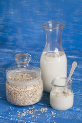 bottle of milk, cereal and cream on a blue wooden background