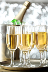 Glasses of champagne on bright background