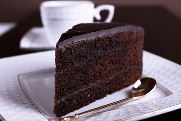 Piece of chocolate cake on white plate, closeup