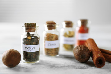 Assortment of spices in glass bottles on wooden background