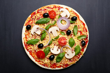 Raw pizza with vegetables on wooden background